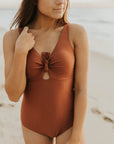 Cute, modest rust colored one piece swimsuit, with ties in the back and front.