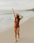 Cute, modest rust colored one piece swimsuit, with ties in the back and front.