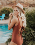 Cute, modest rust colored one piece swimsuit, with ties in the back and front.
