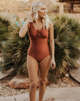 Cute, modest rust colored one piece swimsuit, with ties in the back and front.