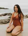 Cute, modest rust colored one piece swimsuit, with ties in the back and front.