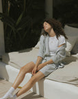 Striped long sleeve matching shorts and top beachwear set for women.